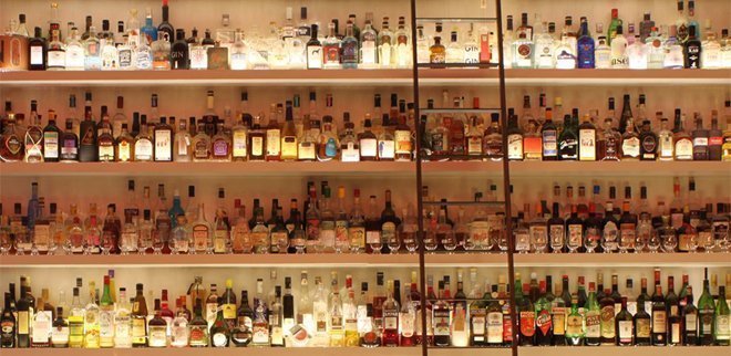 Eine Bar mit vielen Regalen voller alkoholischer Getränke.