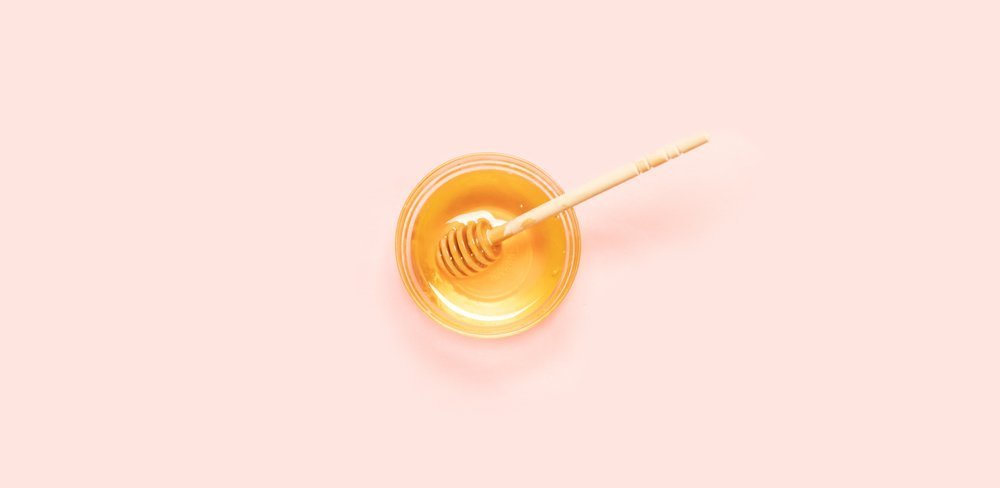 Honig im Glas auf rosa Hintergrund
