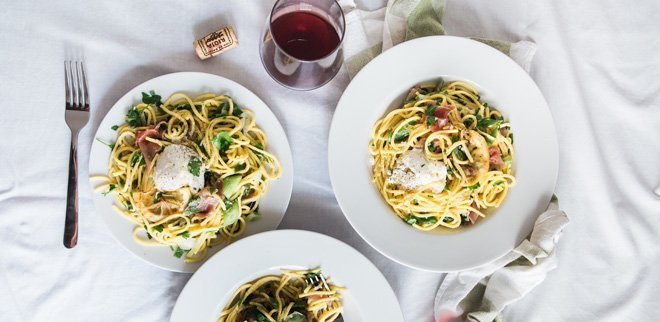 Teller mit Spaghetti und Wein von oben.