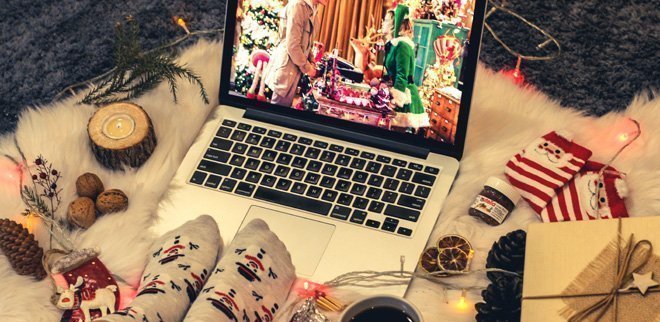 Aufgeklappter Laptop mit Weihnachtsfilm und Weihnachtsdeko.
