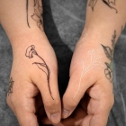 Weisses Blumen-Tattoo auf der Hand.
