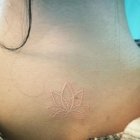 Weisse Lotusblumen-Tattoo im Nacken