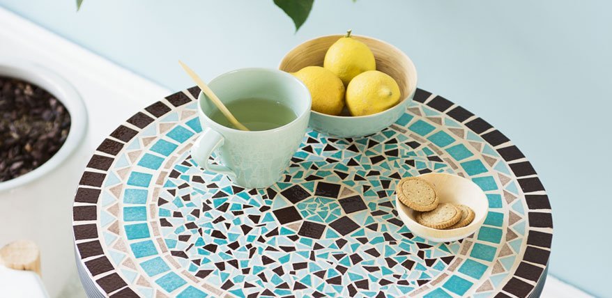 Tasse Tee auf Mosaik-Tisch.
