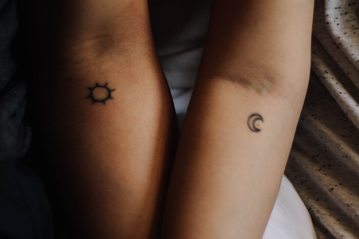 Ein Paar mit einem Sonnen und einem Mond-Tattoo.