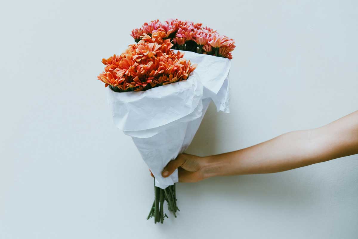 Eine Hand hält einen Strauss Blumen – doch welche Bedeutung steckt dahinter?