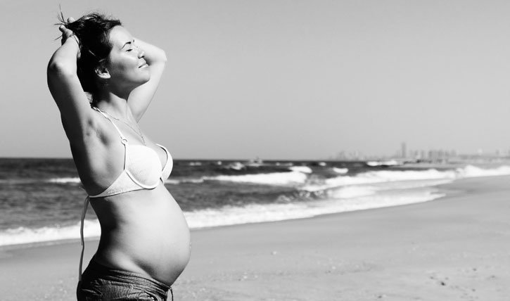 Schwangere Frau am Strand.